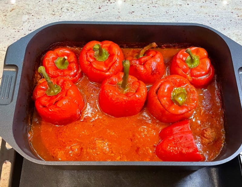 Die gefüllten Paprikaschoten aus dem Ofen nehmen und zusammen mit der Sauce servieren.