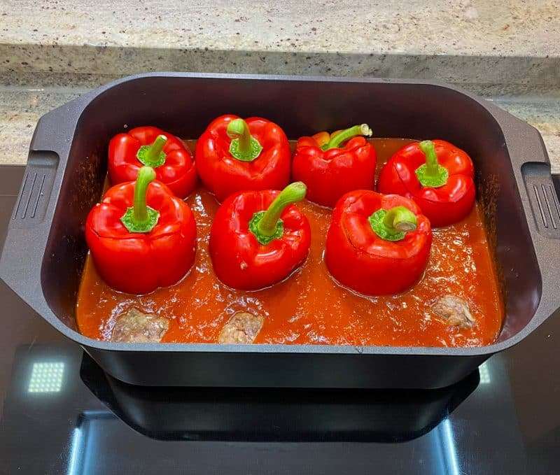 Paprikaschoten garen: Die gefüllten Paprikaschoten in die Sauce setzen. Den Topf oder Bräter mit geschlossenem Deckel oder Alufolie in den vorgeheizten Backofen stellen. Nach ca. 35 Minuten den Deckel oder die Folie entfernen und die Paprikaschoten weitere 15-20 Minuten garen. Die Gesamtgarzeit beträgt in der Regel 45-55 Minuten, je nach Backofen. Die Paprikaschoten sollten gar sein und etwas angeschmort, aber noch bissfest