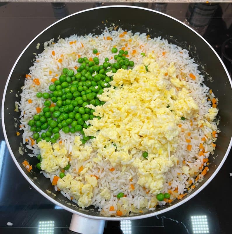 o Gib den gekochten Reis in die Pfanne. Rühre gut um und brate alles 3-5 Minuten, bis der Reis heiß ist. o Füge die Erbsen hinzu und mische alles gut durch. Würze mit Sojasauce, Salz und Pfeffer nach Geschmack. o Füge die gebratenen Eier hinzu und mische sie gründlich unter den Reis.
