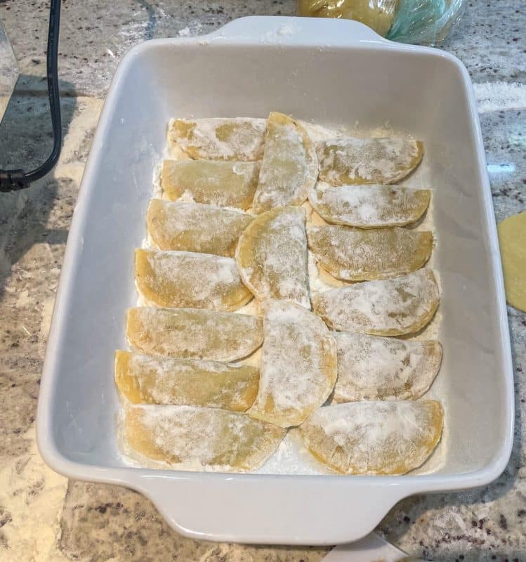 Fertige Ravioli mit Mehl bestäuben