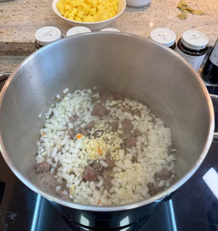 Zwiebeln und Knoblauch hinzufügen Gulaschsuppe