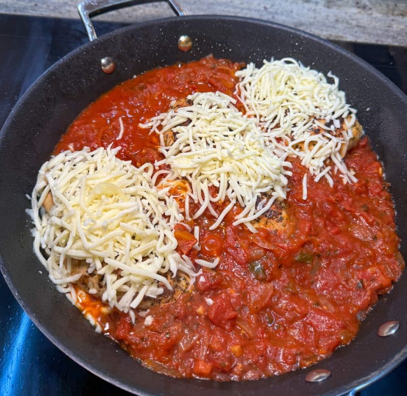 Hähnchenbrustfilets in Tomatensauce mit geriebenem Mozzarella bestreut
