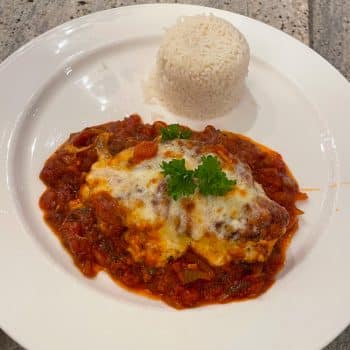 Hähnchenbrustfilet mit Tomatensauce und geschmolzenem Käse, serviert mit Reis
