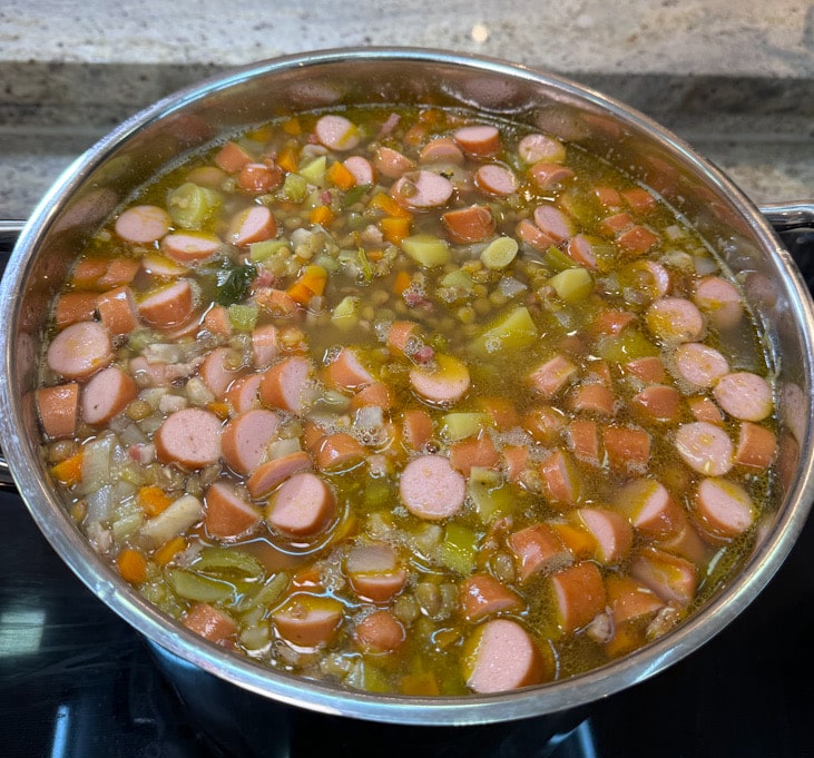 Linsensuppe mit untergehobenen Würstchen kurz vor dem Servieren