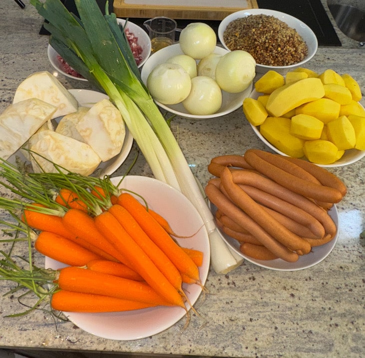 Zutaten für klassische Linsensuppe: Gemüse, Würstchen, Tellerlinsen und Speck in der Vorbereitung