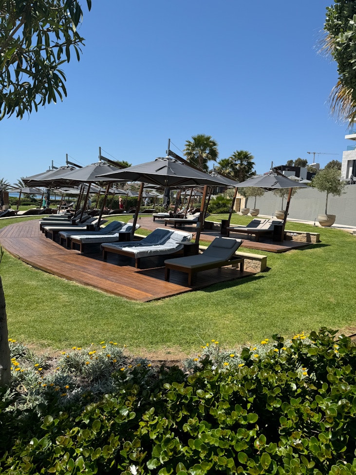 Poollandschaft im Amara Hotel Zypern mit Liegen und Meerblick
