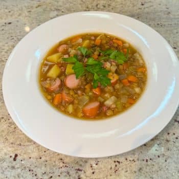 eller mit klassischer Linsensuppe, serviert mit Würstchen und frischer Petersilie