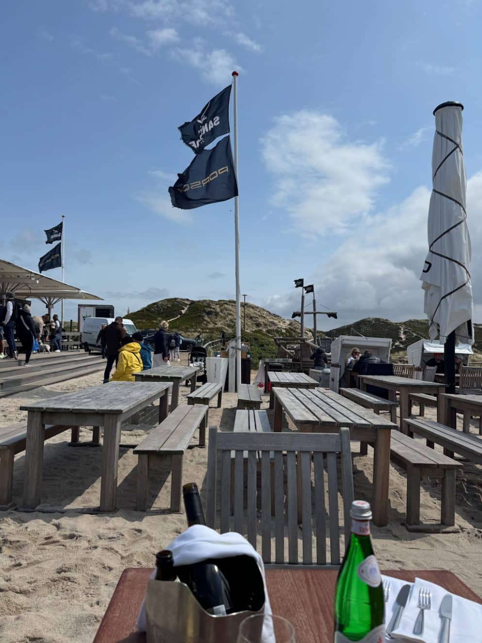 Weitläufige Terrasse der Sansibar mit Flagge und Tischen im Sand