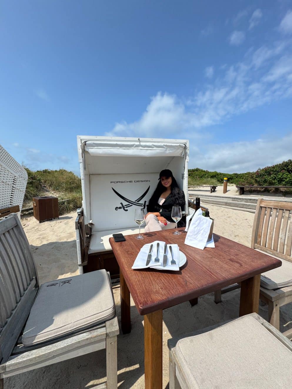 Tisch im Sand vor der Sansibar mit Serviette und Logo