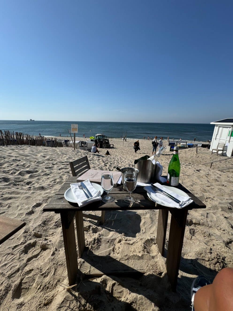 Tisch im Sand vor der Sansibar mit Serviette und Logo