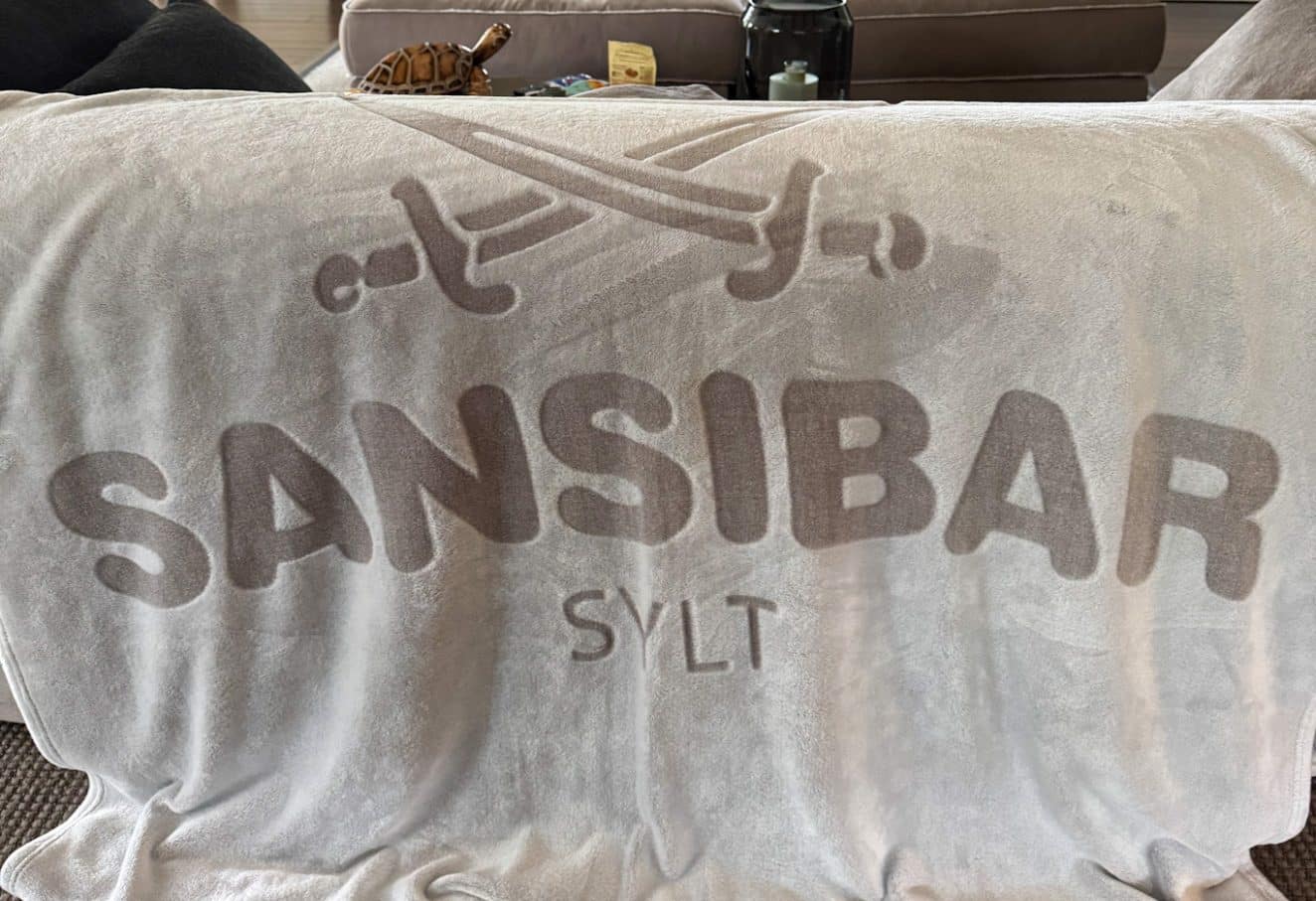 Weiche graue Decke mit großem Sansibar-Logo und gekreuzten Säbeln, aus dem Sansibar Store
