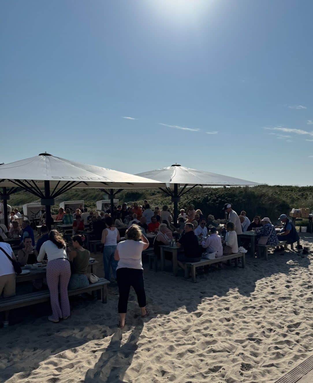 Große überdachte Terrasse der Sansibar mit Gästen und Flaggen
