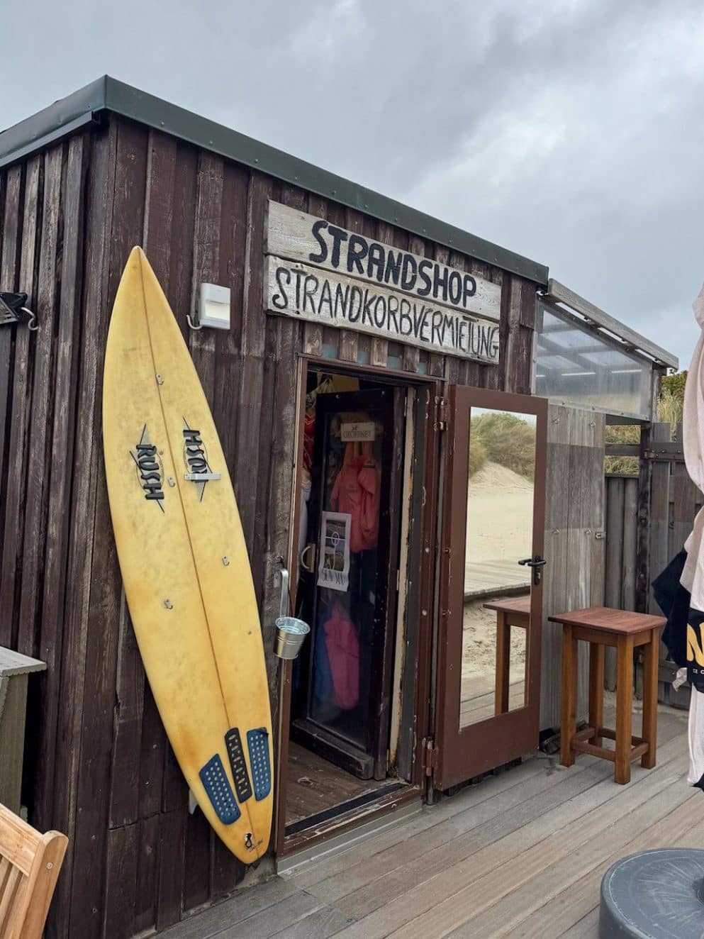 Sansibar Strandshop Sylt mit Surfbrett und Terrasse – Mode, Accessoires & Meerblick direkt am Strand