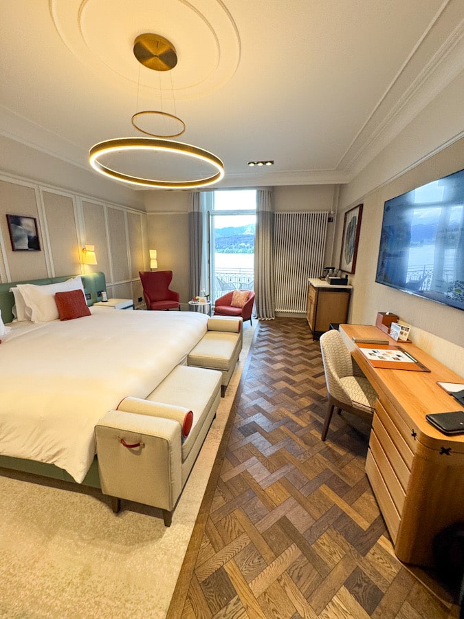 Helles Zimmer im Mandarin Oriental Palace Luzern mit Schreibtisch, Sitzbereich und Blick auf den See