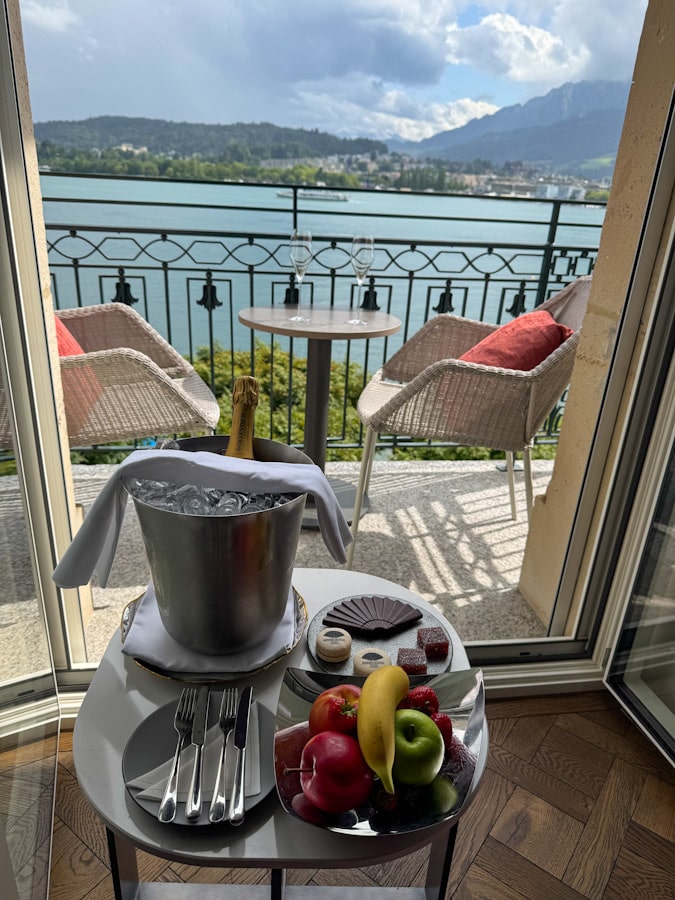 Frühstücksteller mit Obst und Gläsern auf dem Balkon des Mandarin Oriental Luzern mit Seeblick
