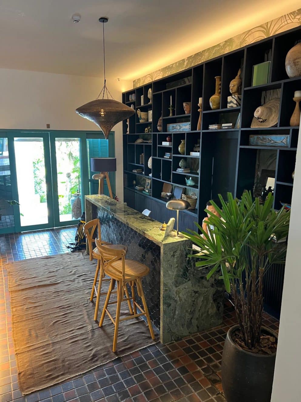 Dekorativer Regalbereich im Vila d’Este Hotel in Búzios, Brasilien – stilvoller Raum mit Holzregalen und gemütlichen Sitzmöglichkeiten. Decorative shelving area at Vila d’Este Hotel in Búzios, Brazil – stylish room with wooden shelves and cozy seating.