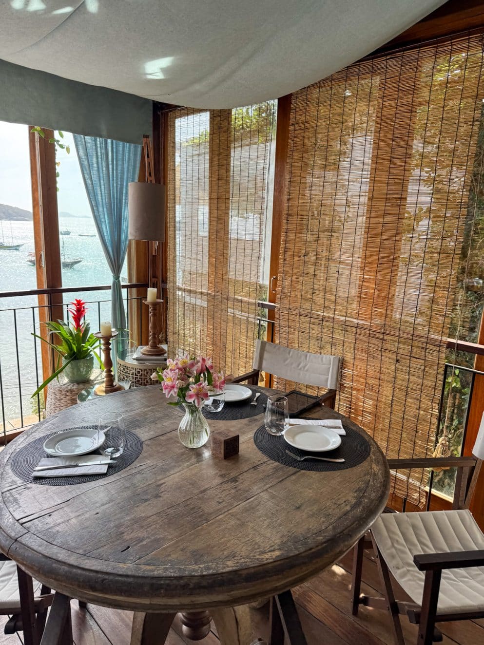 Überdachter Außenbereich im Altto Ristorante & Lounge im Vila d’Este Hotel in Búzios, Brasilien – runder Tisch mit Blumendeko und Blick aufs Meer.

Covered outdoor area at Altto Ristorante & Lounge at Vila d’Este Hotel in Búzios, Brazil – round table with flowers and ocean view.