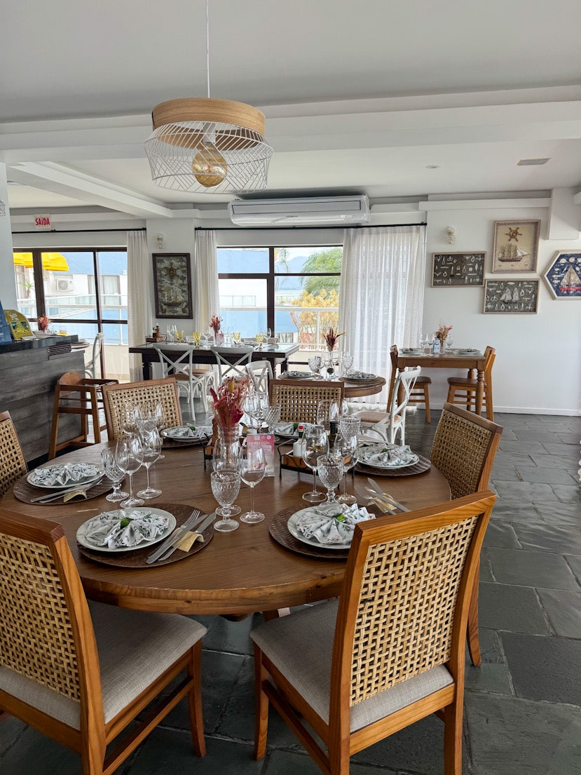 Gedeckter Tisch im ersten Stock des Convés Restaurants in São Francisco do Sul, Brasilien, mit hellem Interior und Blick Richtung Meer.