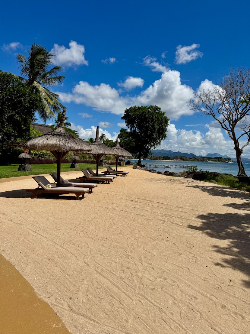 Strand des Oberoi Mauritius mit Liegen und Sonnenschirmen am Meer | hotelandfoodlover